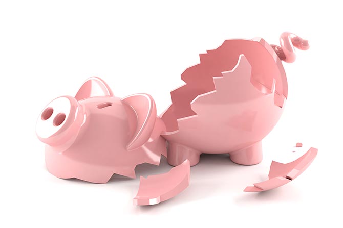 A pink piggy bank that has been broken into several pieces.