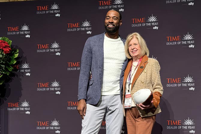 Ginger accepting a signed football from a pro football player